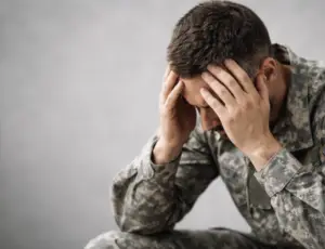 Veteran experiencing stress related to PTSD symptoms, illustrating mental health conditions evaluated in VA disability claims